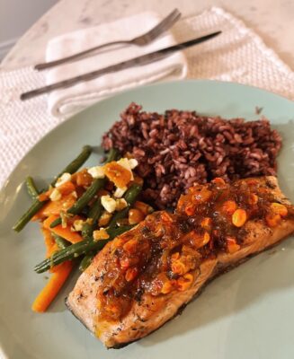 a plate with roasted salmon, green beans and carrots and wild rice.