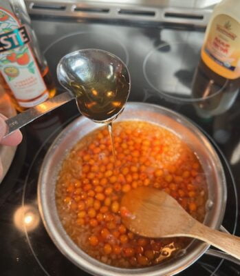 A spoonful of Agave nectar over a pan of simmering seaberries, shallots and Orange liqueur.
